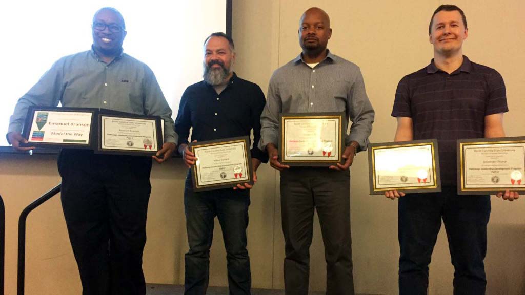 Four DELTA employees are pictured with their certificates for completing Pathways Leadership programs