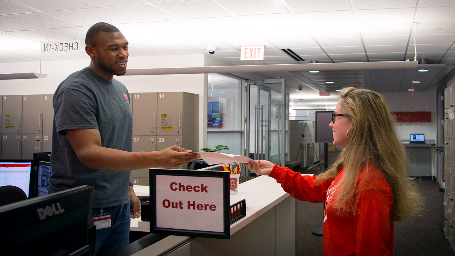 DELTA Testing Services Associate Brad Collins (left) pictured with a student who is turning in a test at the Centennial Campus Test Center.