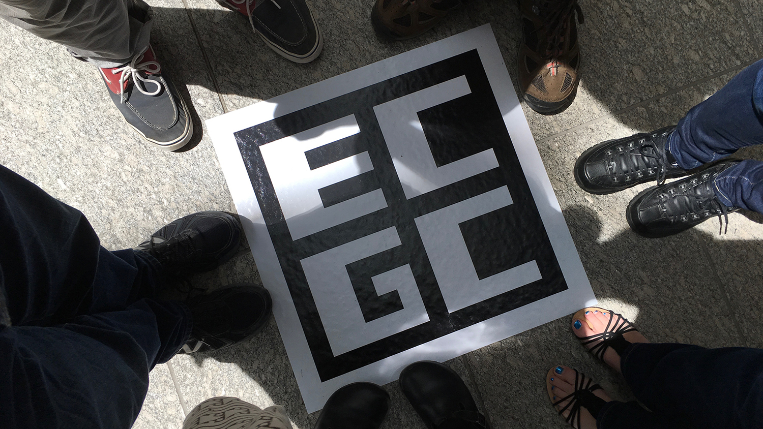 DELTA staff attendees feet pictured from above with the ECGC logo on the ground.