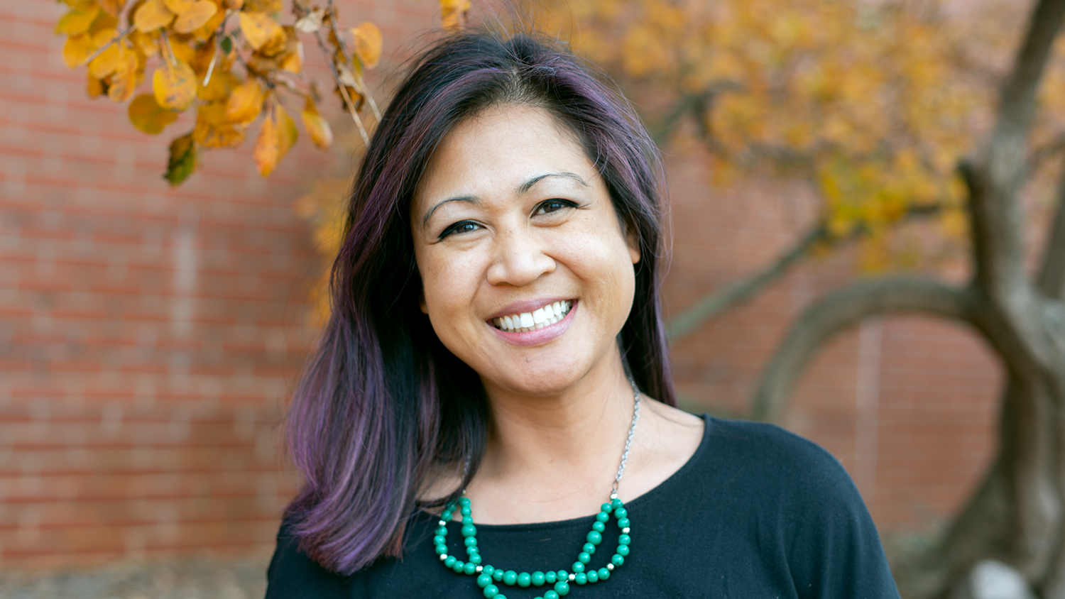 Arlene pictured posing in front of a tree on Centennial Campus.