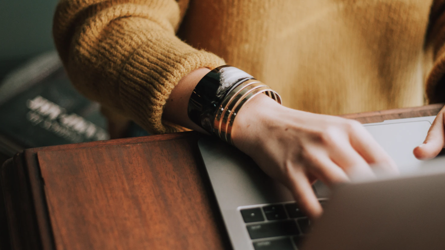 Hands typing across a laptop's keyboard.