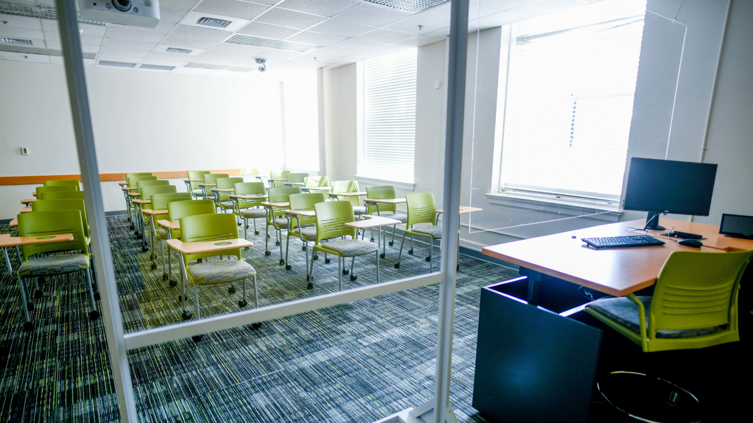 Empty NC State classroom with green seats.