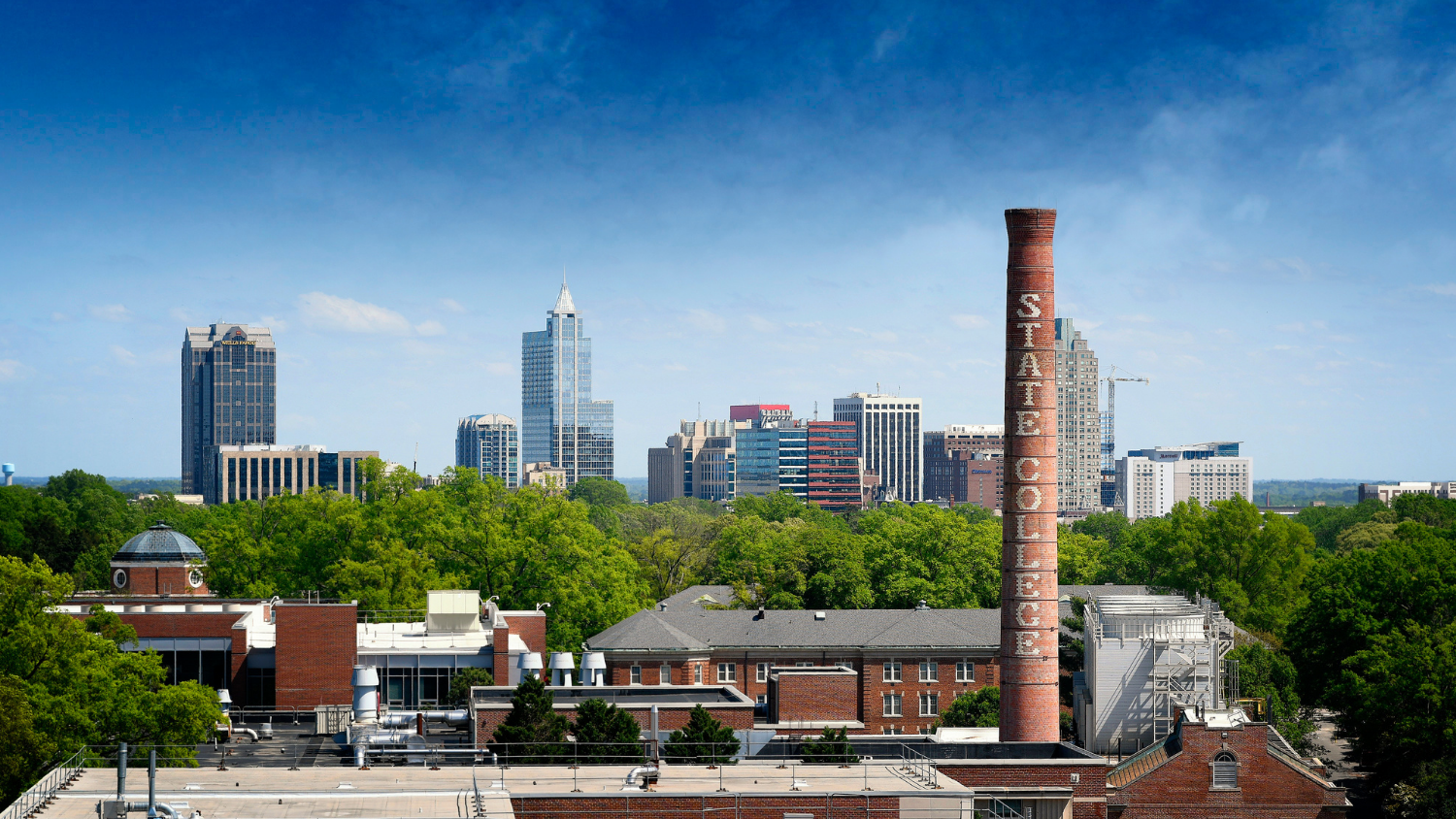 Downtown Raleigh skyline, framed by the State College smoke stack. Photo by Marc Hall.