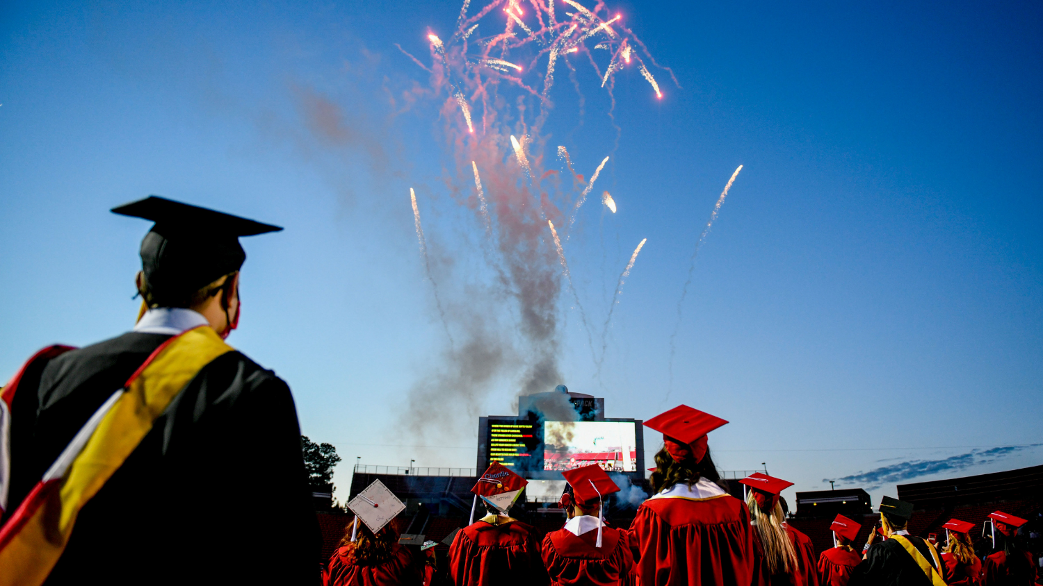 Spring 2021 graduates watch as fireworks shoot at Carter-Finley Stadium.