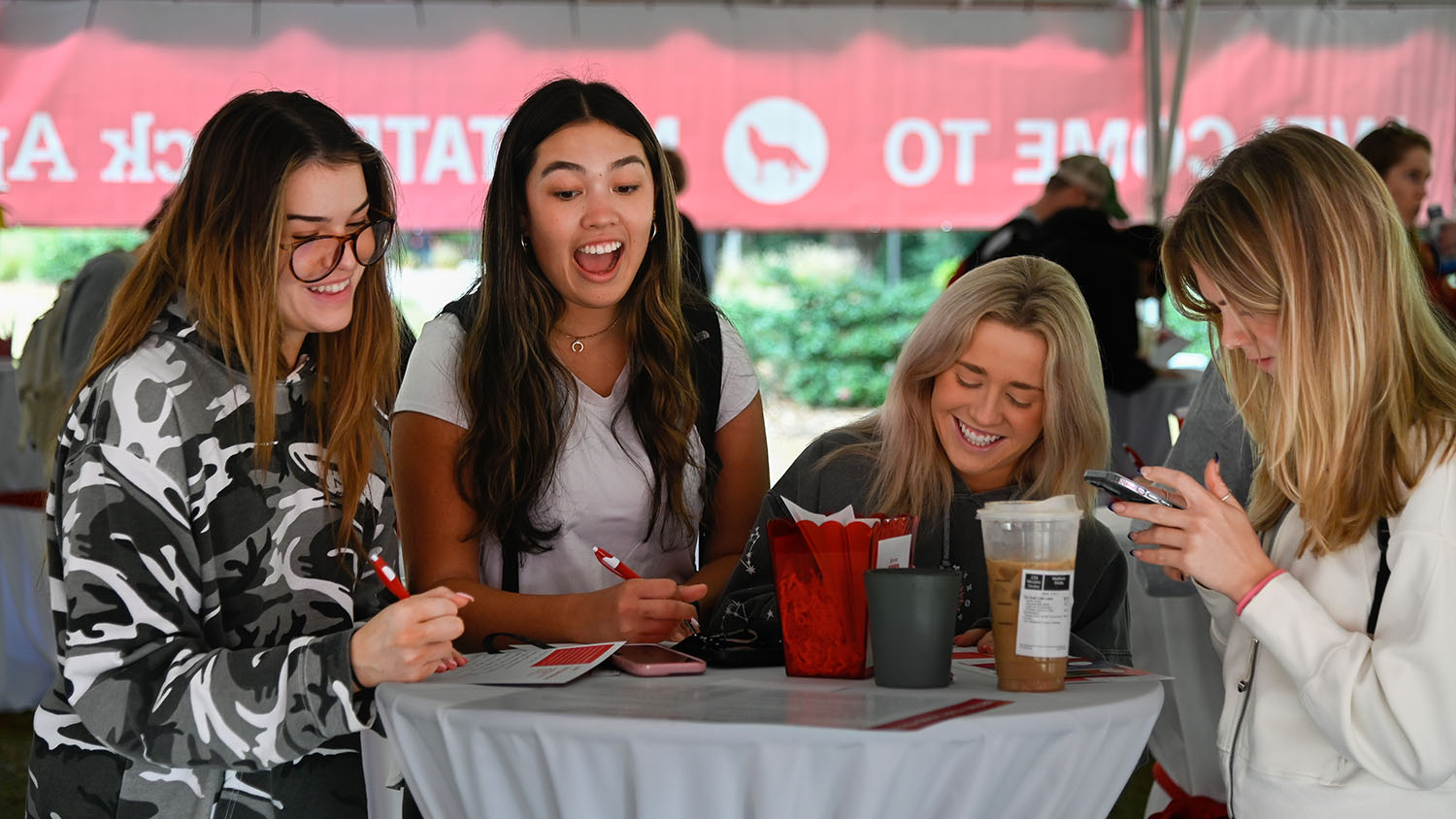 Four NC State students talking and laughing.