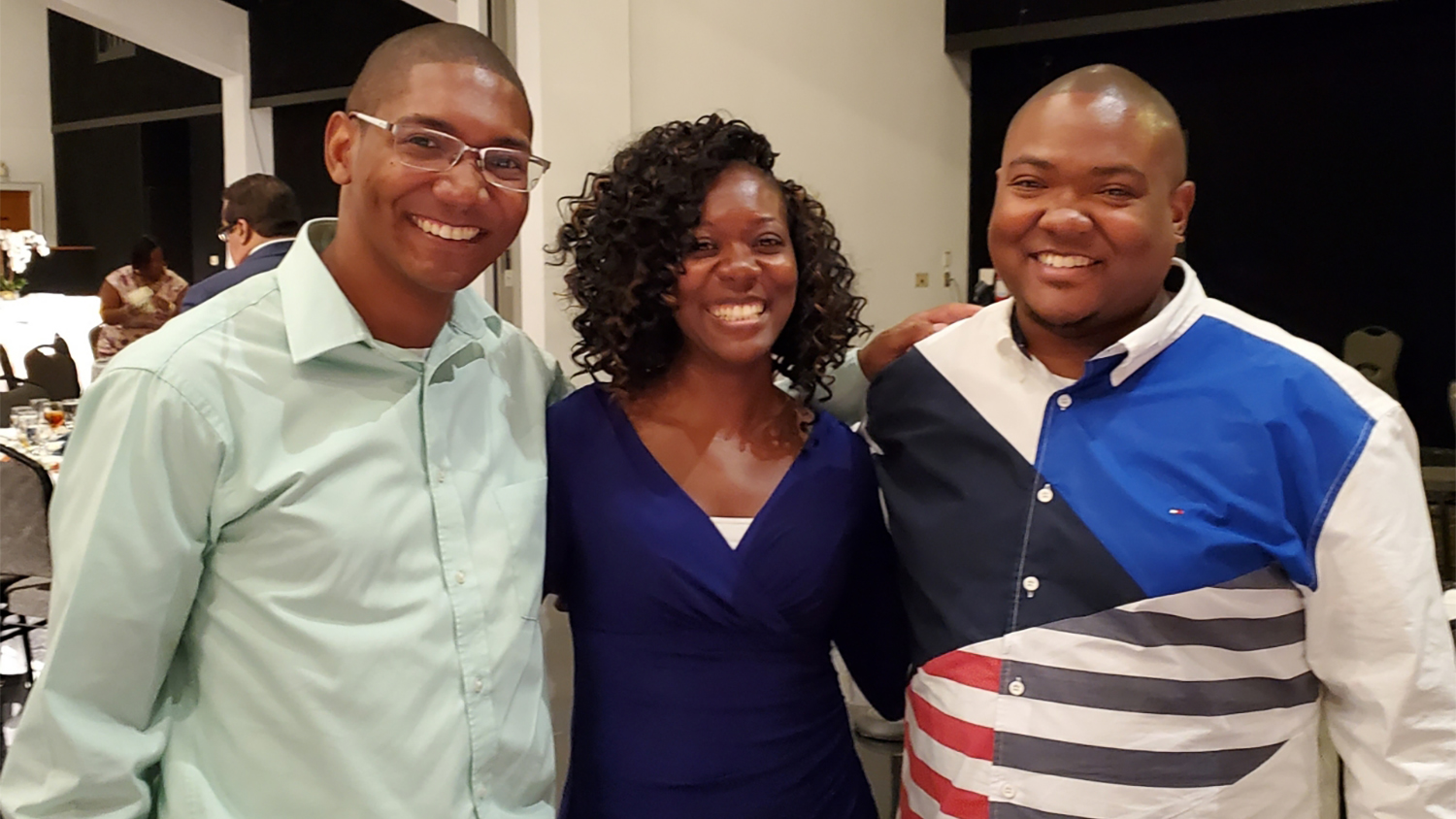 White standing between her brothers, Michael (to her left) and Marcus (to her right) at a family event.