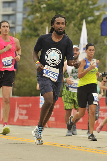 Relly Moorer running on a city street with other runners shown in the background during the Chicago Marathon in October of 2021