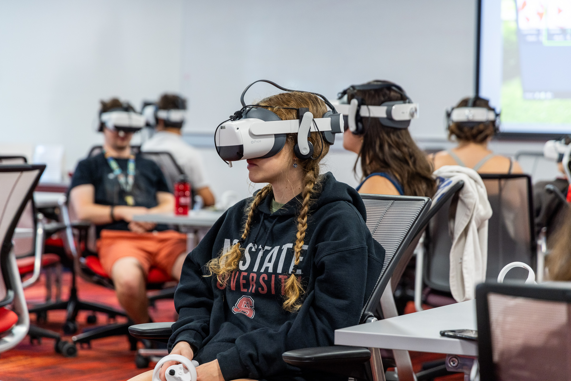 A student in a classroom wears a virtual reality headset.