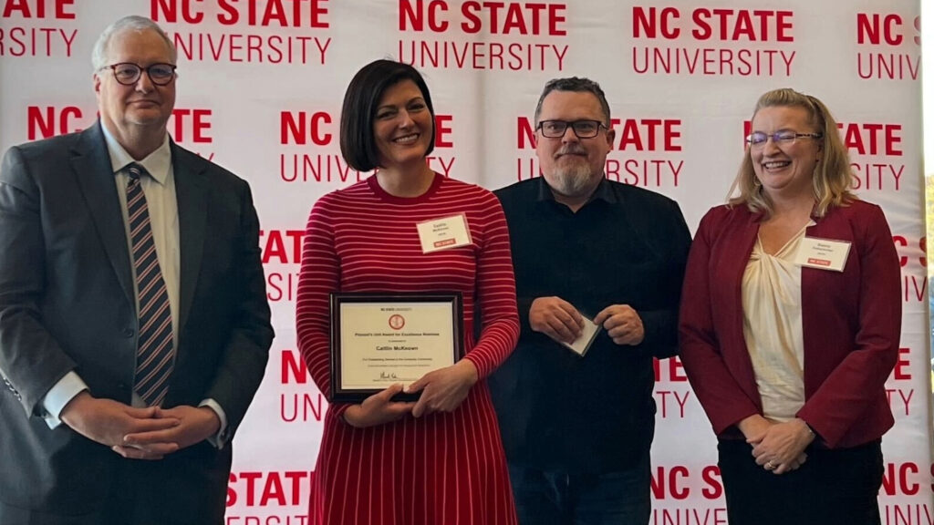 A group of four people posing together at an awards ceremony