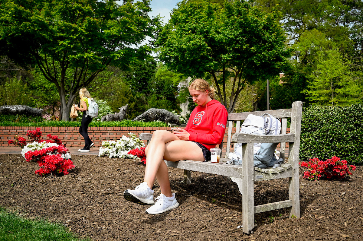 Students enjoy some outside study and relaxing time on a warm spring afternoon near flowers blooming close to Alexander Hall. Photo by Becky Kirkland.