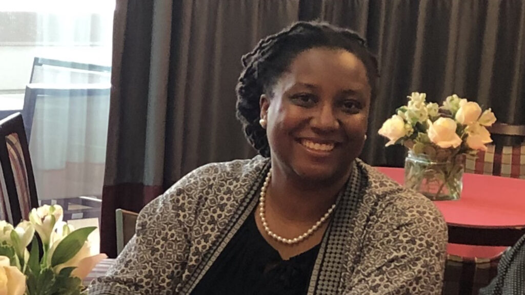 A woman sitting at a table smiling