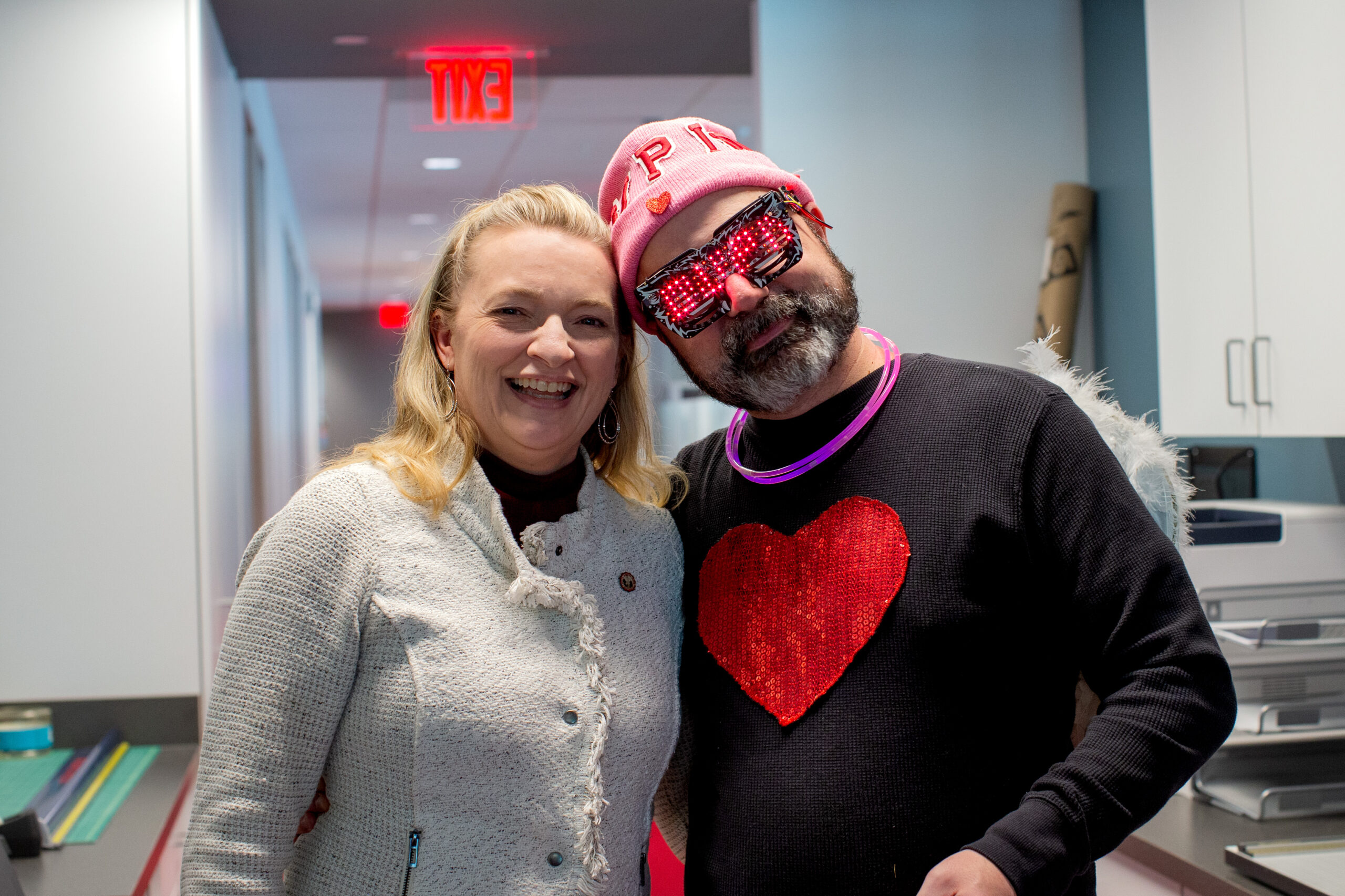 A woman posing with a man dressed up as Cupid on Valentine's Day.